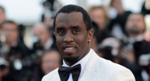 American music mogul wearing a white tuxedo at a red carpet event
